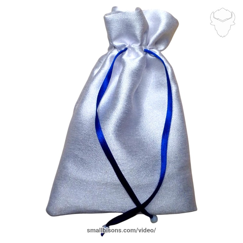Bolsa caracolera blanca con cinta azul tejida en bisutería artesanal